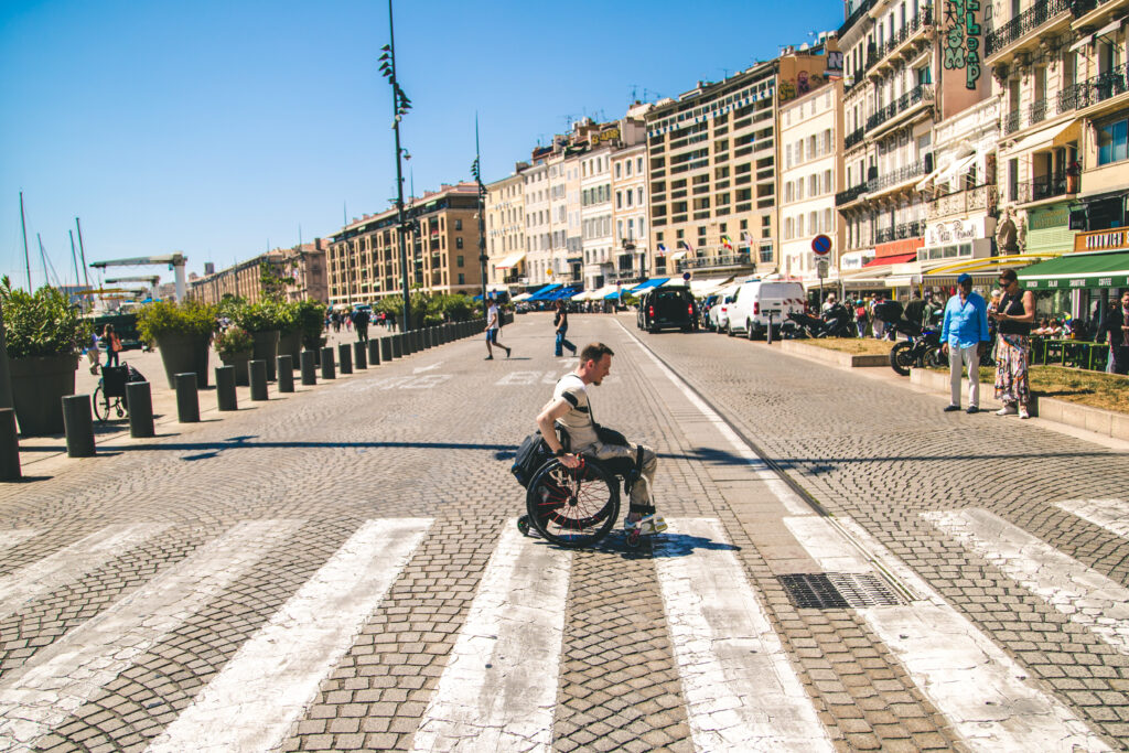 Homme en fauteuil roulant qui traverse la rue